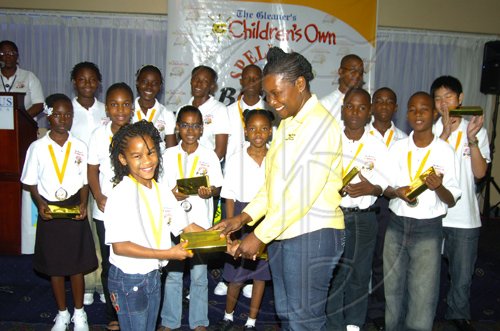 Winston Sill/Freelance Photographer
Georgia Cunningham, representative of Mall and Tropical Jewellers present a watch to Lariecia Harvey, Trelawny parish champion.