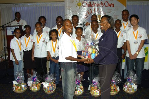 Winston Sill/Freelance Photographer
Sandra Geohagan-Green, Promotions Co-ordinator of Lasco Distributor's Ltd presents a gift basket to Champion Boy Owayne Rodney.