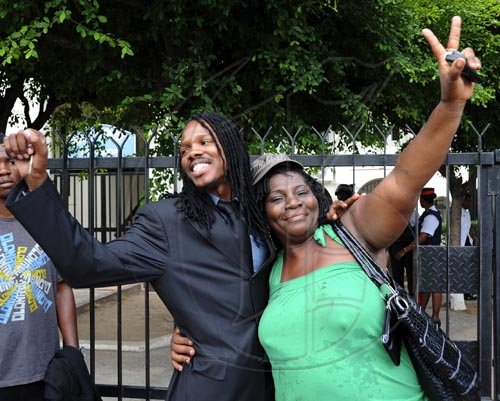 Ian Allen/Staff Photographer
Peoples National Party Youth Organization(PNPYO) President Damian Crawford left get a hug from a Jamaica Labour Party supporter outside the Supreme Court on King Street during the case between Michael Stern and Richard Azan on their dual citizenship for the North West Clarendon constituency.