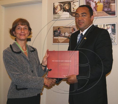 Contributed                                                                                                                                                                  Chief of Communications Services at the Canadian Dairy Commission,  Chantal Paul (left), presents a copy of a book on the history of the Commission to Minister of Agriculture and Fisheries, Hon. Dr. Christopher Tufton  (right), ), when the Minister and his team visited the
Commission, recently.