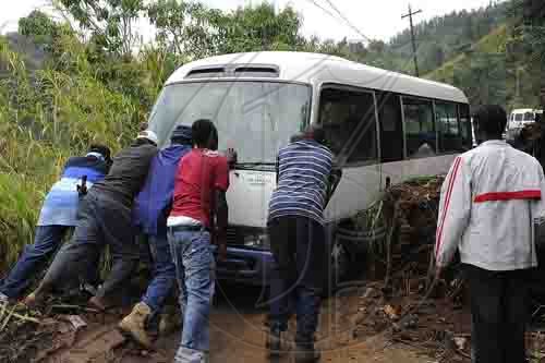 Ian Allen/Photographer
Residents of Guava Ridge in Mavis Bank push a bus that was stuck in mud from a in a landslide along the Guava Ridge to Mavis Bank main road.