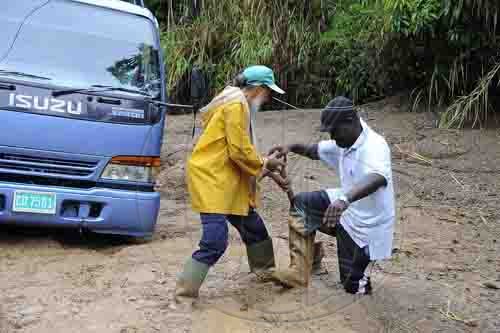 Ian Allen/Photographer
A man gets help  to free himself from mud that blocked section of the guava Ridge to Mavis Bank main road after overnight rains caused landslides in the area.